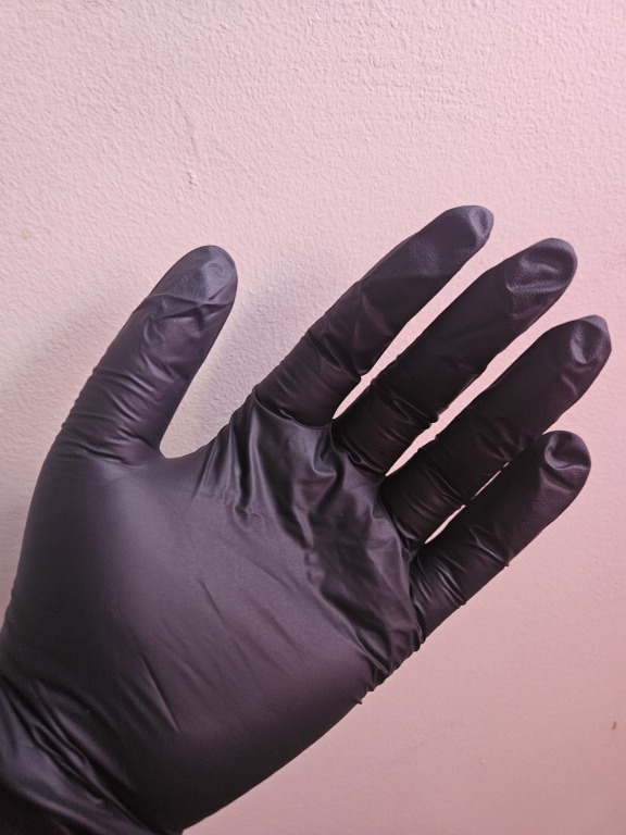 a hand wearing a black nitrile glove